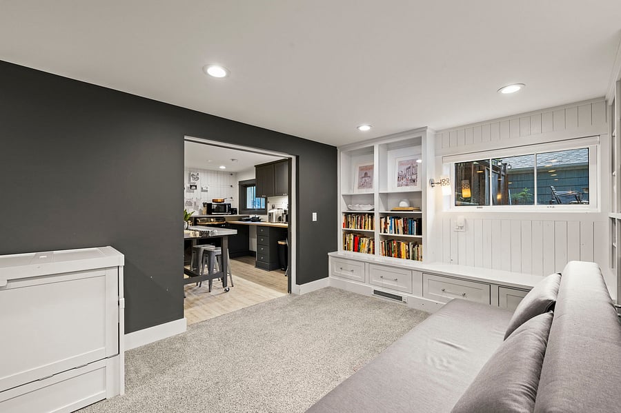 Living room from couch end: shows transition from lounge area toward kitchenette and dining nook.
