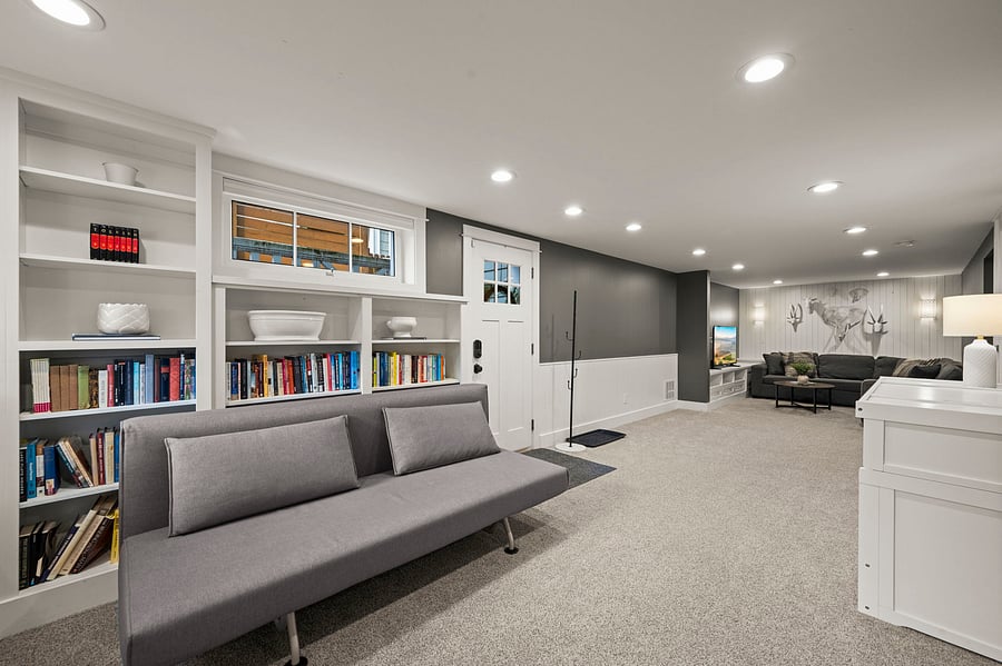 Wide main-room view from Murphy-bed area toward TV lounge, front entry, and built-in storage.