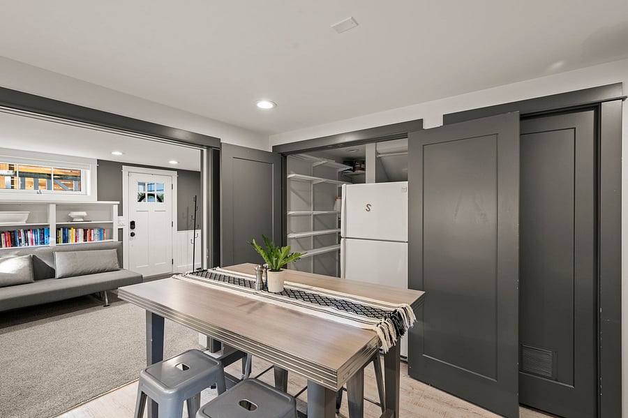 Dining island and refrigerator view with sliding storage doors and open sightline to living area.