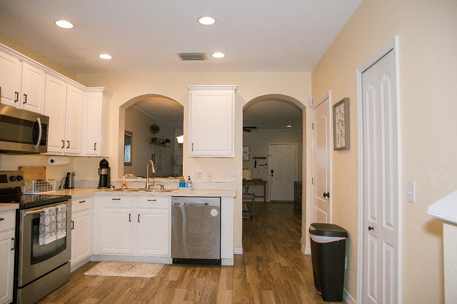 Upper and lower cabinets in the kitchen stocked with service for 4. Dishwasher, sink with garbage disposal. This kitchen includes basic appliances like a coffee maker and a can opener.
As you walk through the archway into the kitchen, the first door is the half bath. The 2nd door is under-stairs storage.