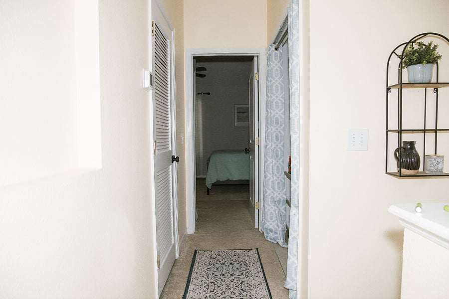 View at the top of the stairs. Behind the curtains is washer/dryer and laundry storage area. AC unit is behind the door on the left. Looking forward you see the entrance to the master bedroom.
