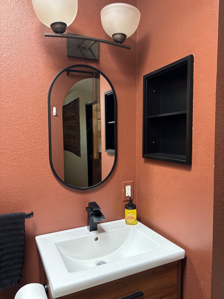 Sink, vanity and inset wall shelf.