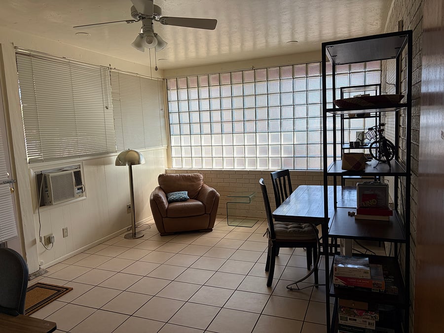 Activity room with reading chair, lamp and side table. A desk and chair (barely pictured on lower left corner).
