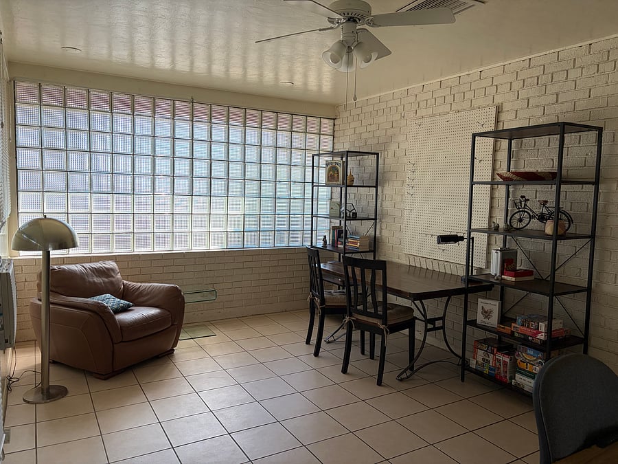 Activity room with puzzle/game table, bookshelves (stocked with variety of books, puzzles, and games).