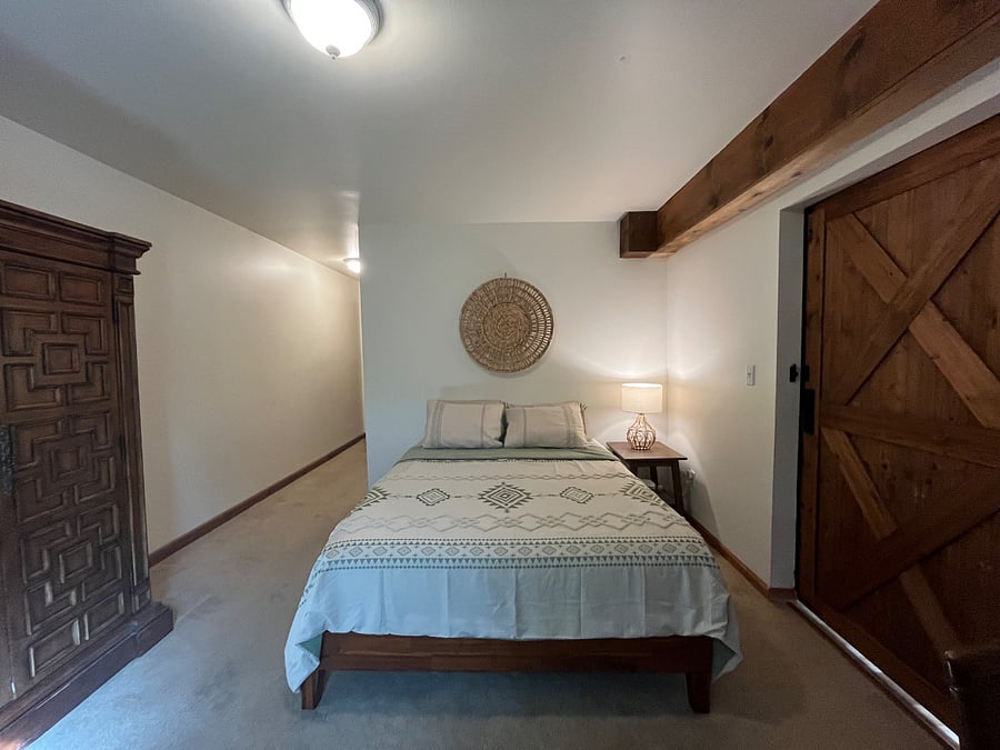 Queen sized bed with armoire for hanging clothes and drawers for folded clothes.