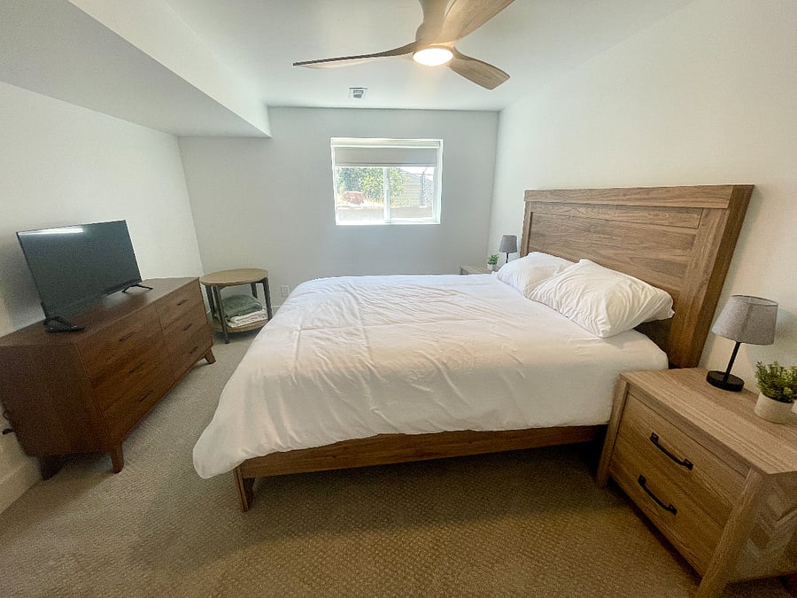Bedroom with queen bed, spacious closet, and TV.