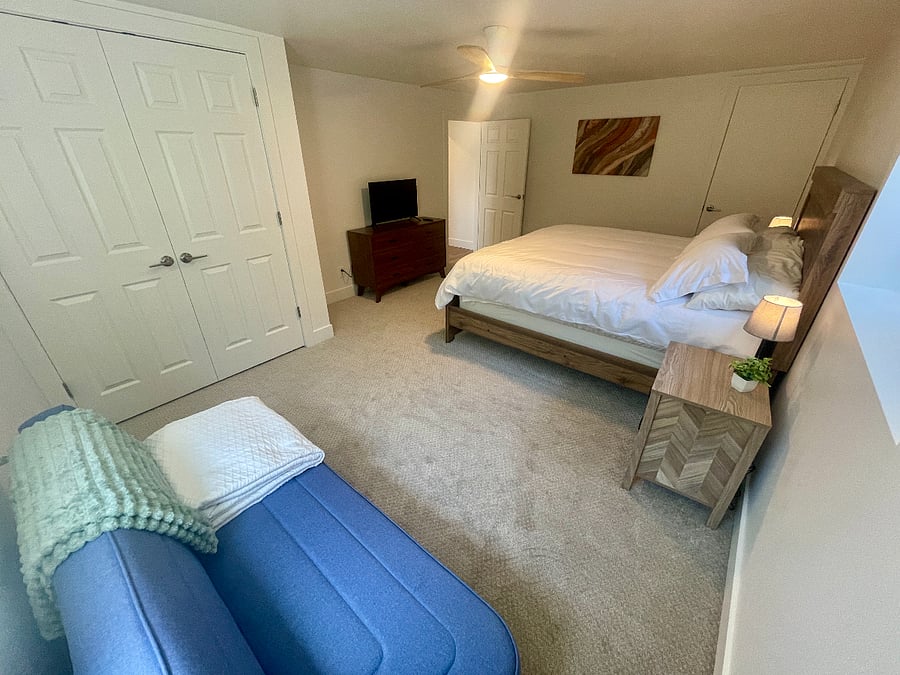 Large bedroom with king bed, spacious closet, TV, and futon.