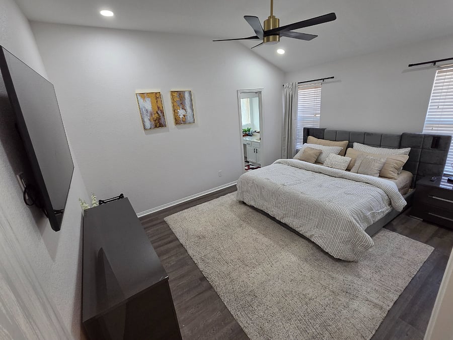 Master bedroom with a plush king bed featuring a Nectar mattress, multiple USB charging ports, 180 tilt smart TV, and lightdimming blackout curtains for restful sleep.