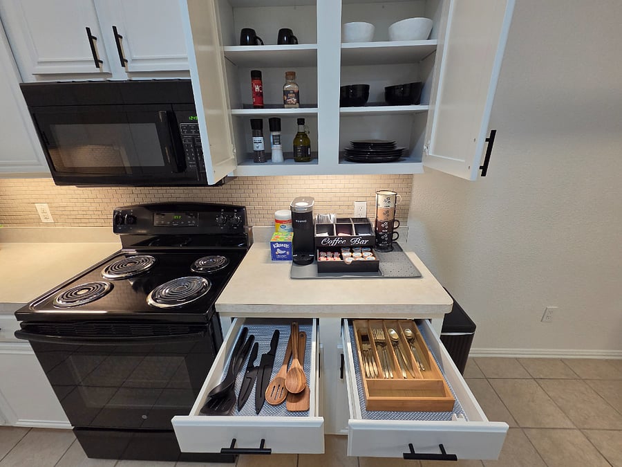 Wellequipped kitchen featuring organized drawers, stocked cabinets, and a readytouse coffee bar for busy mornings.