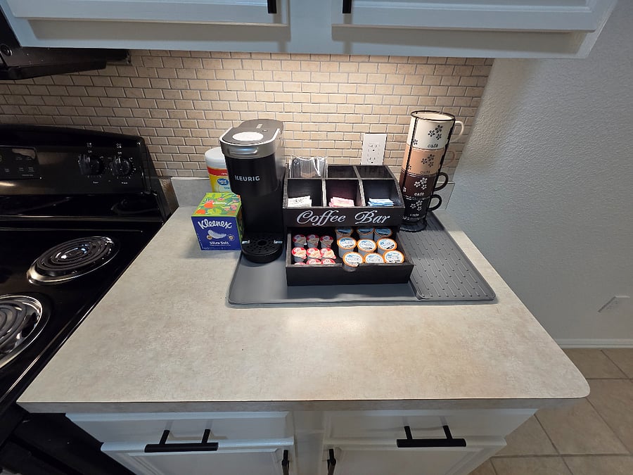 Fully stocked coffee station with pods, creamers, and sweeteners for an easy start to the day.