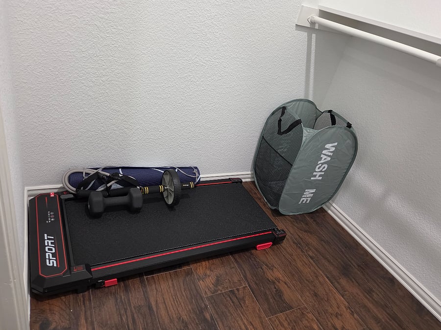 Compact inhome fitness corner with treadmill, dumbbells, yoga mat, and balance pads perfect for staying active during long-term stays.