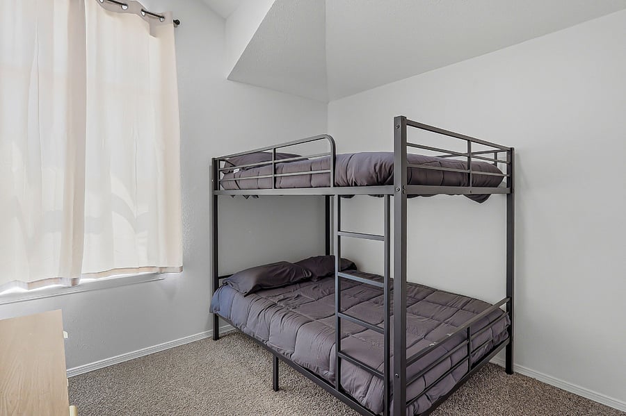 1st bedroom with full size bunk beds and dresser with closet