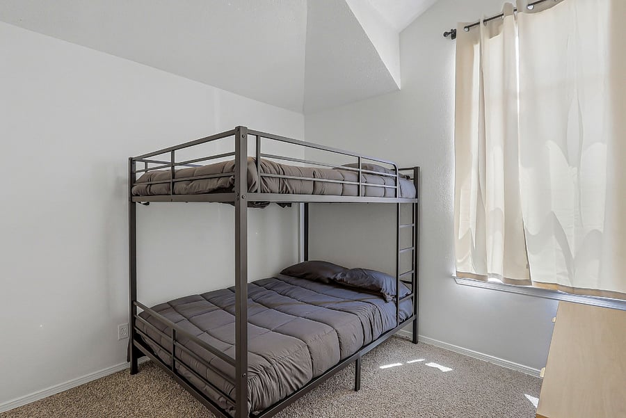 2nd bedroom with full size bunk beds and dresser with closet