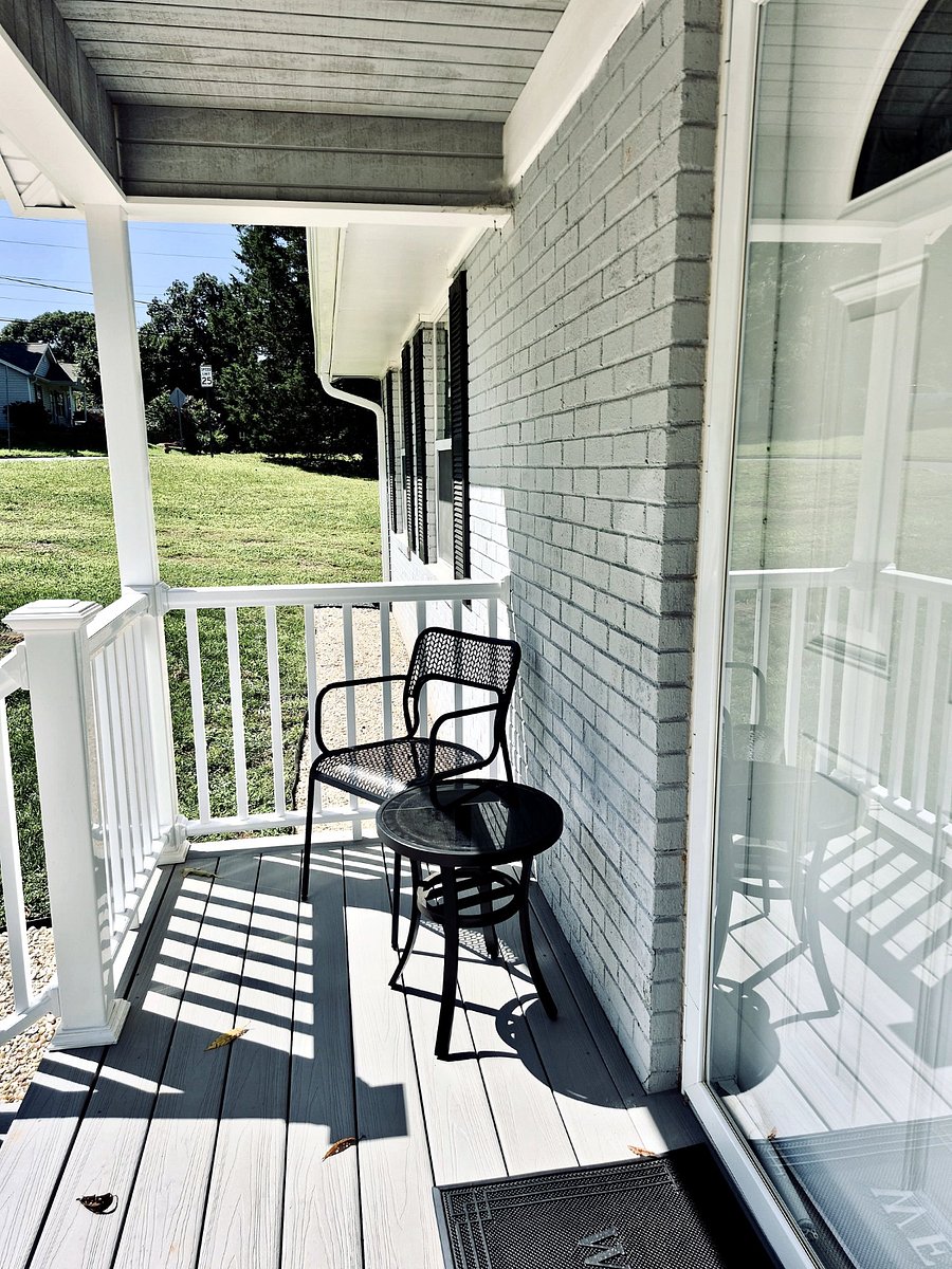 Covered front porch with seating on both sides. 