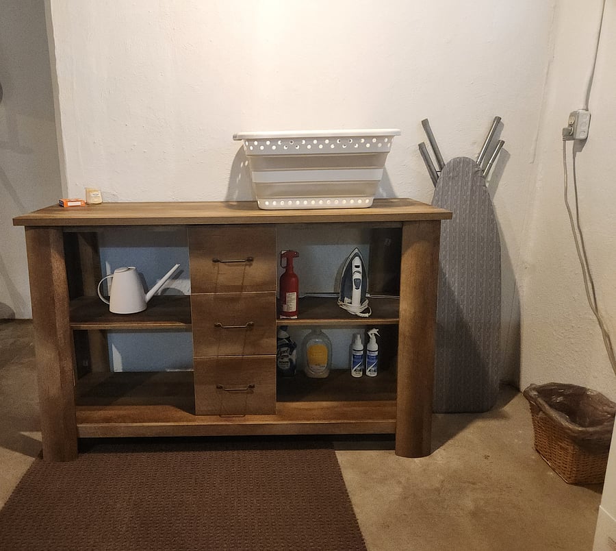 Washer, dryer, drying rack, ironing board, iron, laundry folding surface, laundry basket, and cleaning supplies all located in basement.