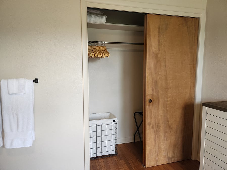 Bedroom 1 (closet includes extra sheets, blanket, hamper, wood hangers, and luggage rack)