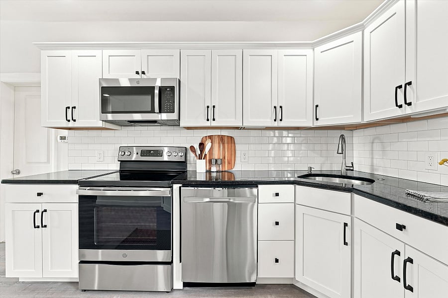 Remodeled kitchen with granite countertops, stainless steel appliances, dishwasher, & garbage disposal.