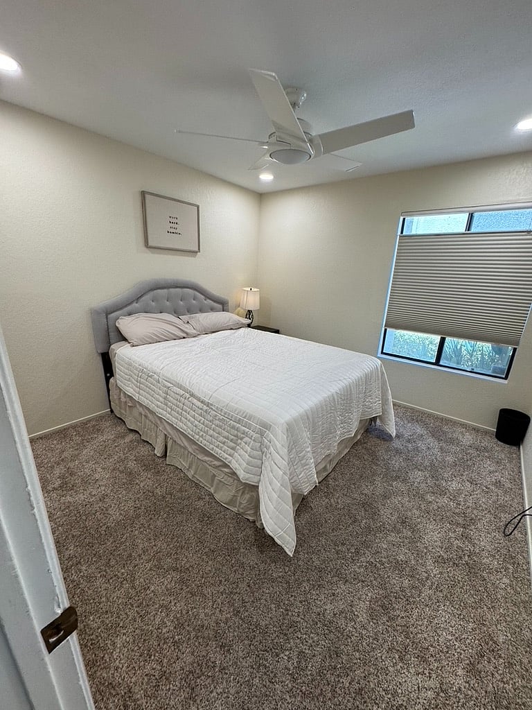 Second bedroom, with black shades, top down bottom up features for light view control, programable Casa Blanca ceiling fan and large flatscreen TV wall mounted