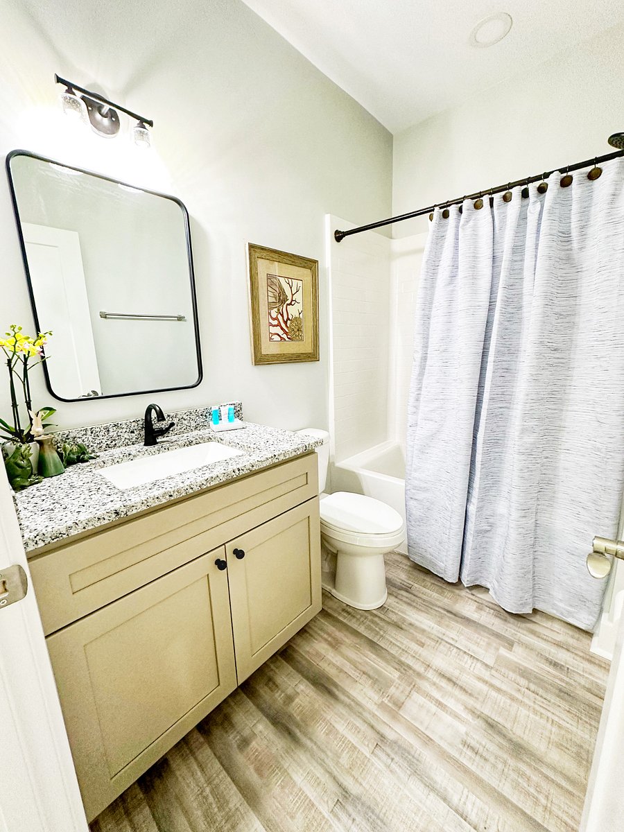 Full hallway bathroom with tub/shower combination and granite vanity.