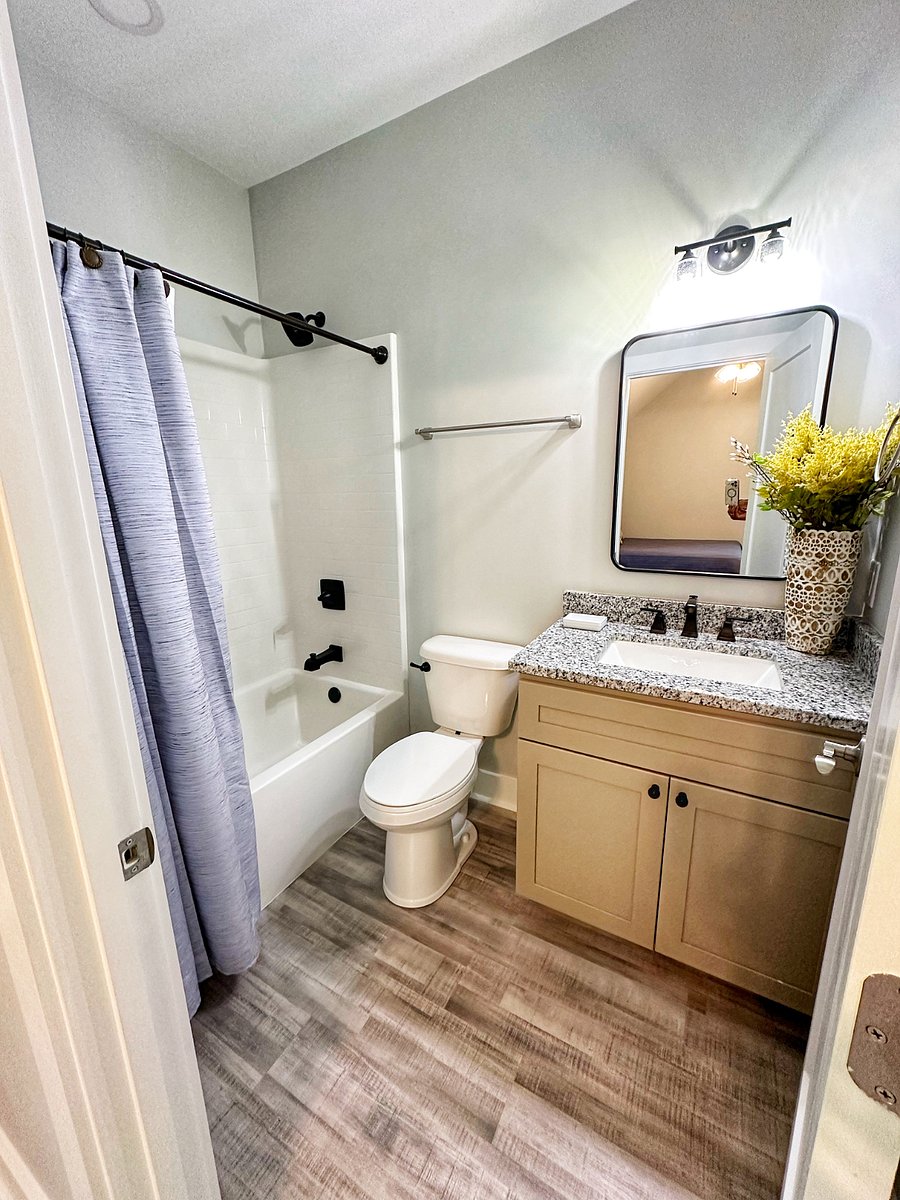 En suite master bathroom with tub/shower combination and granite vanity.