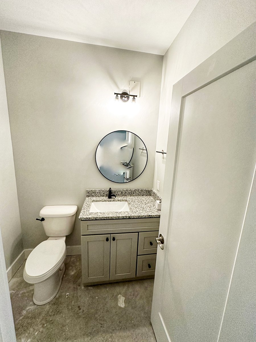 Clean and convenient half bath with granite vanity located on ground floor, accessible though garage and patio.
