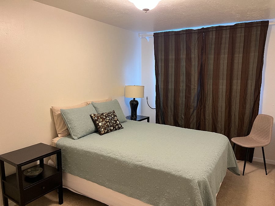 Bedroom with new queen bed and blackout curtains.