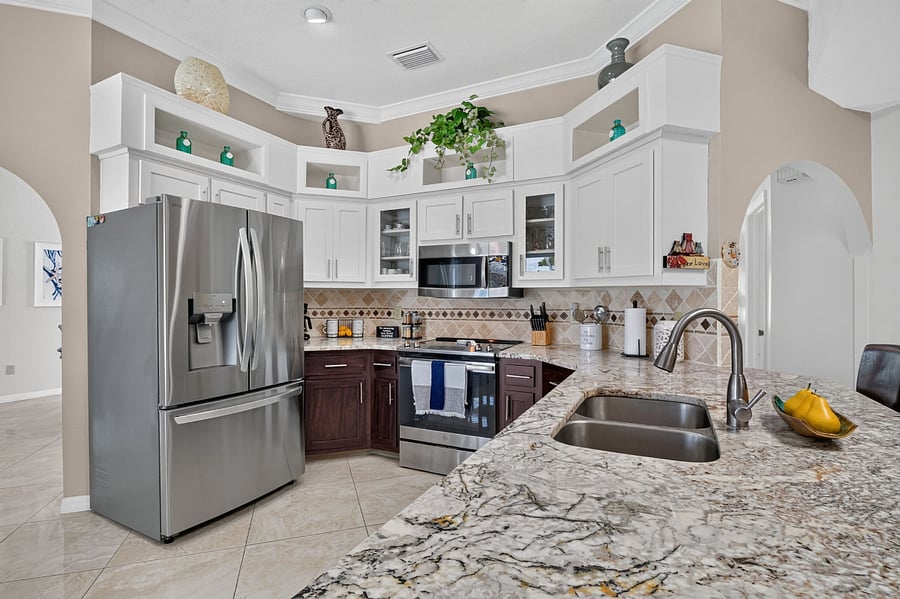 Custom Horseshoe kitchen with extensive breakfast bar with stools and dining area overlooking the pool.