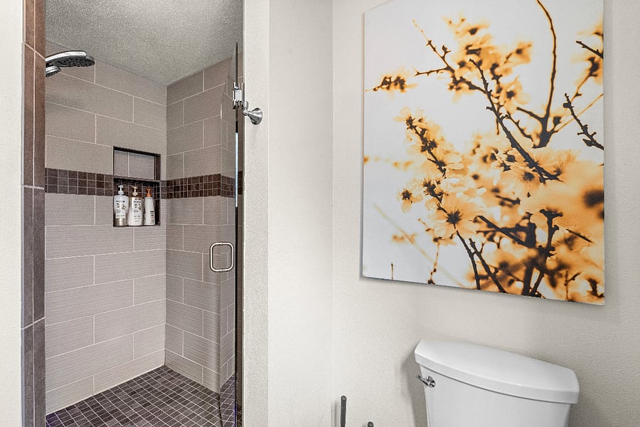 The private primary bedroom bathroom features a stand up shower and toilet. 