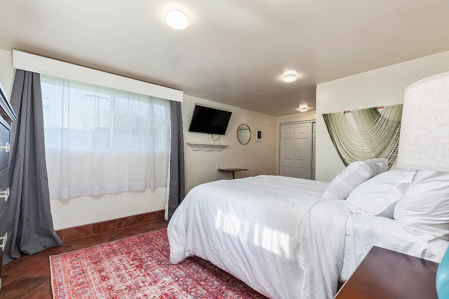 Master Bedroom 1 (Red Suite): Features an adjustable bed (with remote), large TV, attached bathroom, and generous closet space