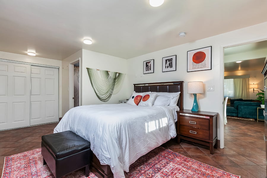 Master Bedroom 1 (Red Suite): Spacious primary bedroom with an attached bathroom, adjustable bed, and generous closet storage