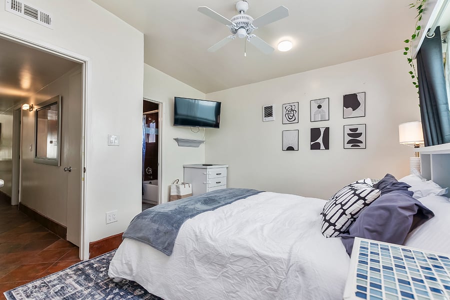 Master Bedroom 2 (Blue Suite): This bedroom includes a TV, dresser, large closets, and attached bathroom.