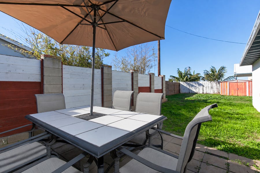 Backyard: The outdoor dining table with BBQ grill and an umbrella for shaded meals