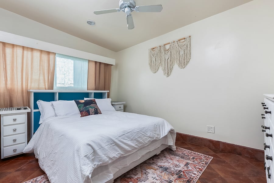 Bedroom 4 (Green Room): A bright fourth bedroom with a window, ceiling fan, and comfortable sleeping space