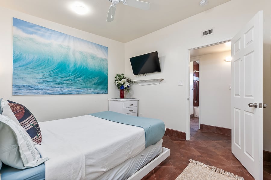 Bedroom 3 (Grey Room): This bedroom also includes a wall-mounted TV and convenient hallway access