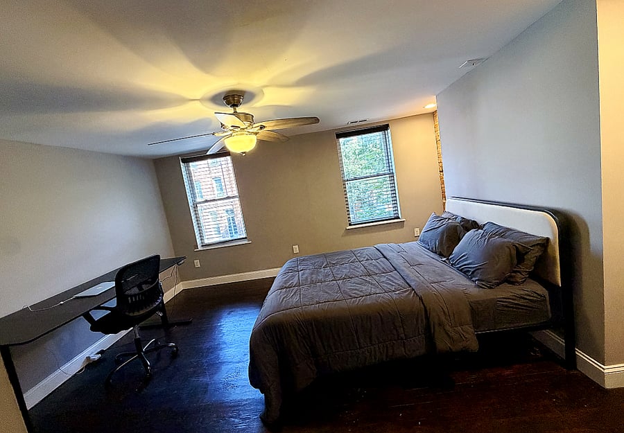 Fully furnished master bedroom with a full station work desk / chair. 
