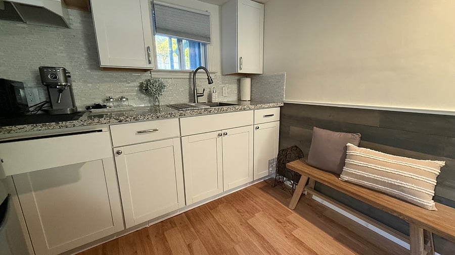 Convenient kitchenette with quartz countertop, cabinetry, sink, microwave, and everything you need for easy everyday living.