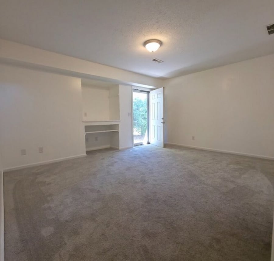 Finished basement area with built in desk and walkout to ground level patio