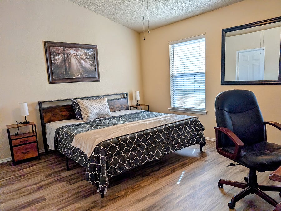 Primary Bathroom with King Bed, Desk, rolling Chair and 55" TV with HDMI that can serve as the second monitor.
