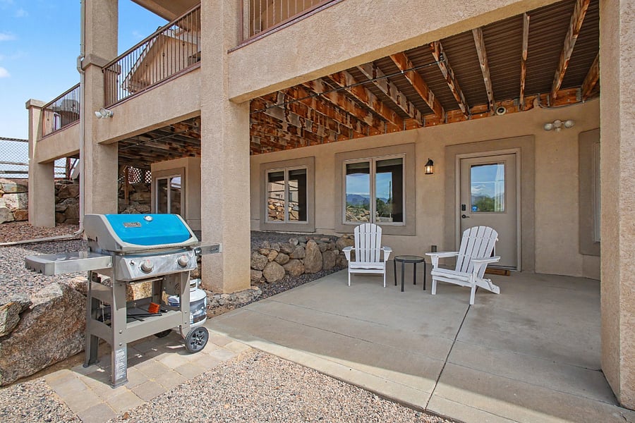 Private covered patio with comfortable outdoor seating and a Weber gas grillperfect for relaxing or enjoying an outdoor meal.