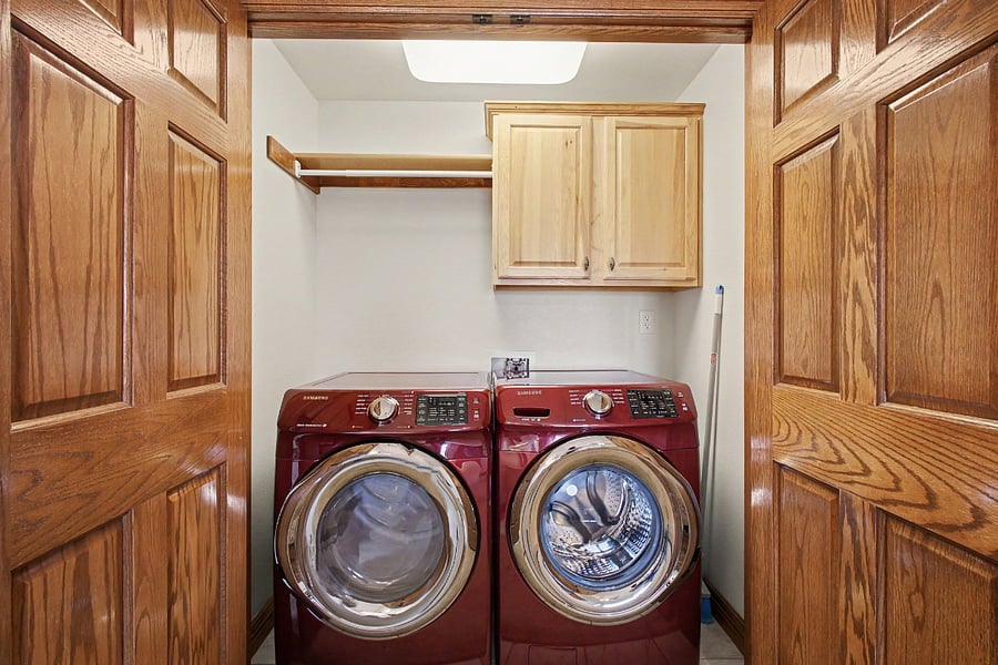 Enjoy the convenience of a private laundry area featuring a full-size, high-efficiency front-load washer and dryer, plus additional cabinet and hanging storage.