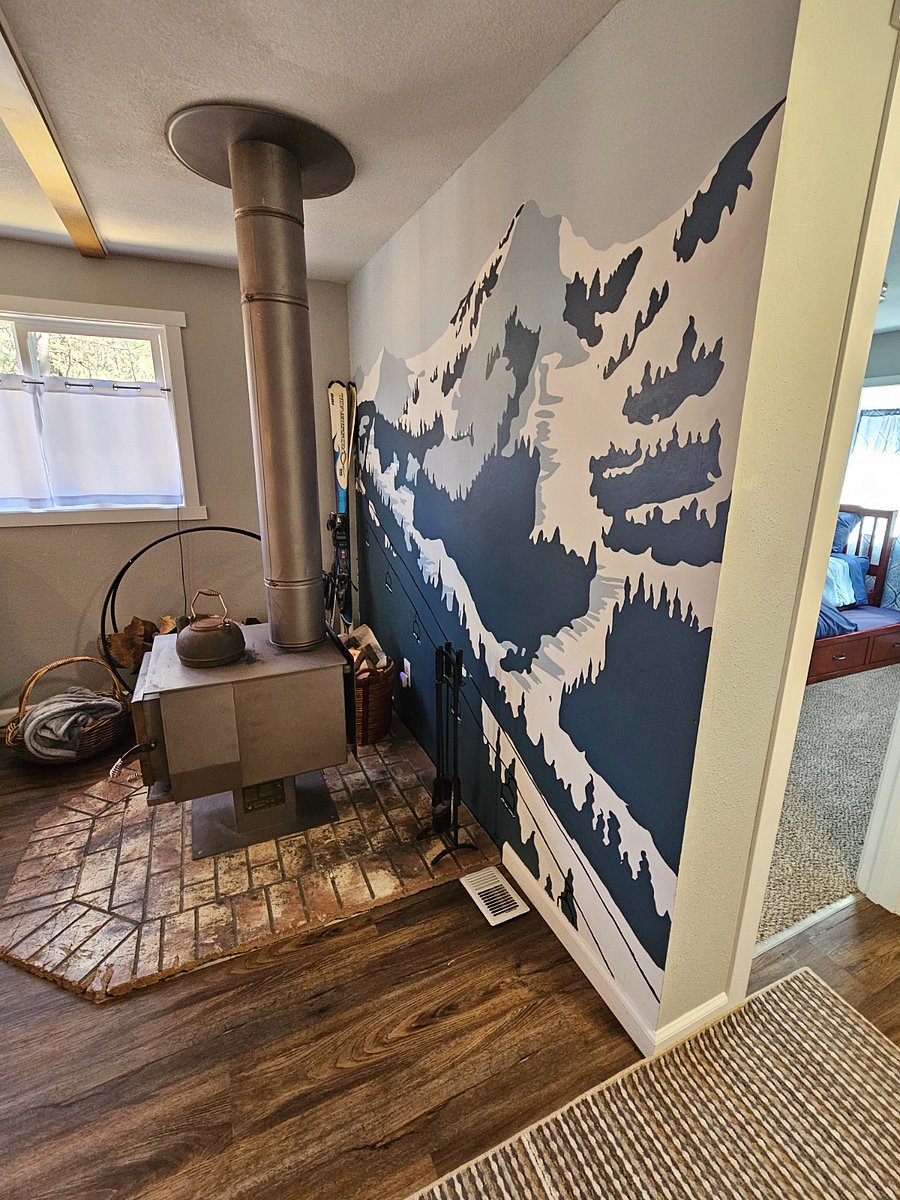 wood burning fireplace with mural feature wall