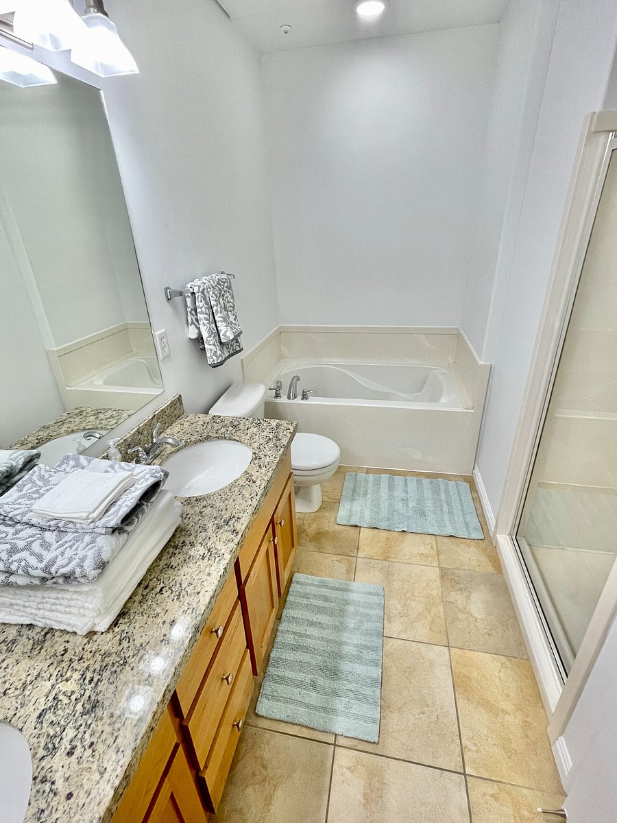Large bathroom with soaking tub, double vanity, standing shower, extra linens