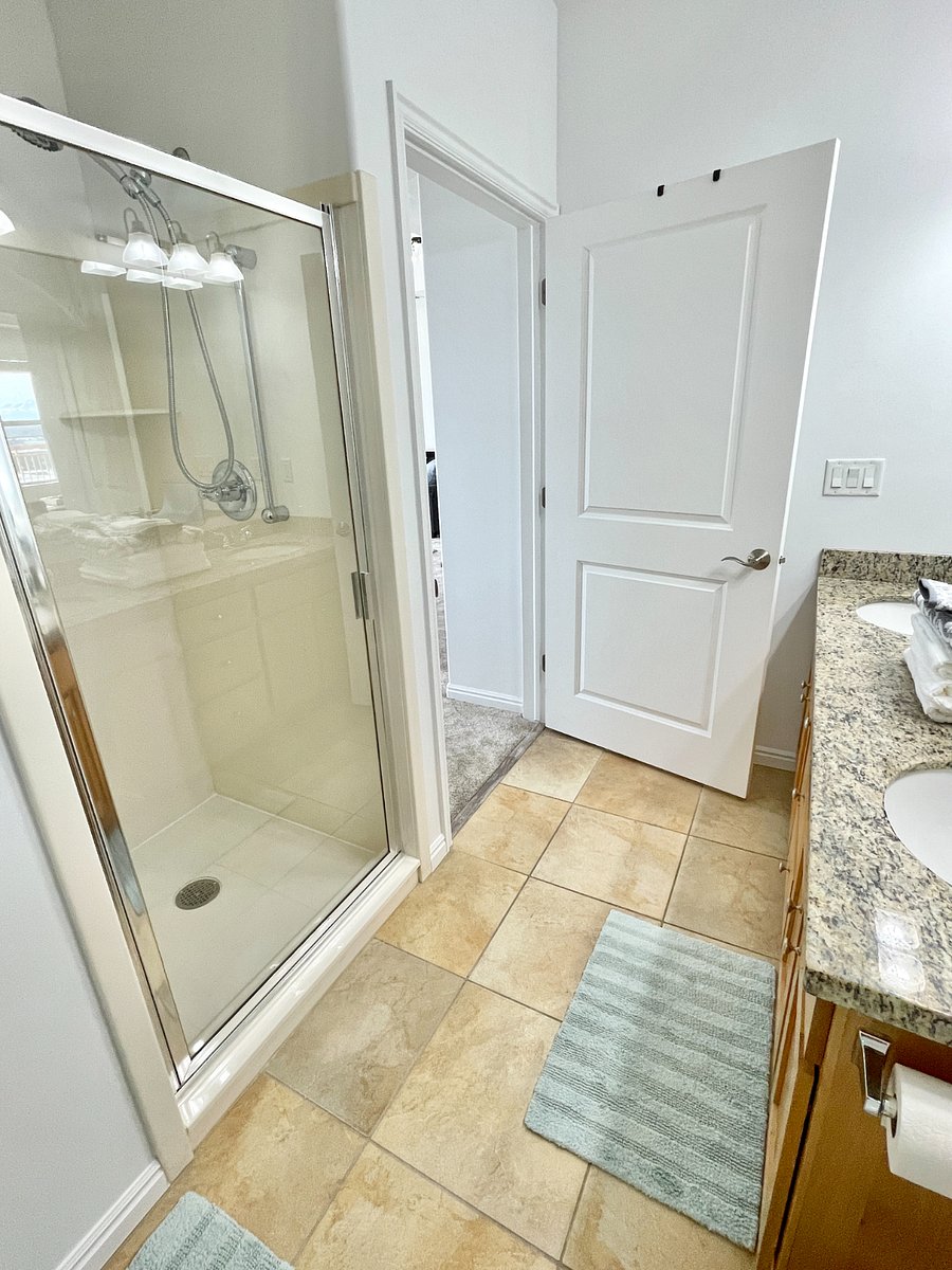 Large bathroom with soaking tub, double vanity, standing shower, extra linens