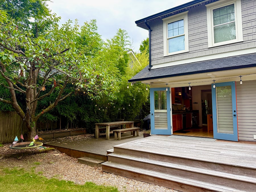 Large backyard with deck, dining table and BBQ