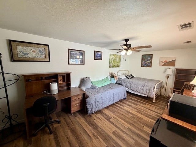 Large furnished private bedroom with 2 windows with blinds, 2 beds, desk, desk chair, rocking chair, microwave, small fridge, shelves and closet storage unit
