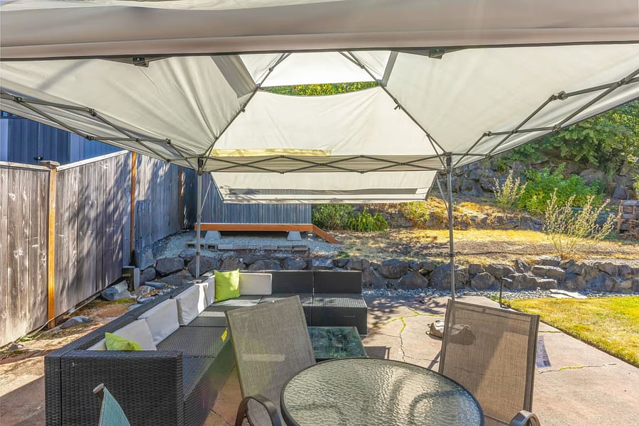 Shade structure was lost in a recent windstorm, but the back yard still has furniture, grill and a yard for the kids to play.