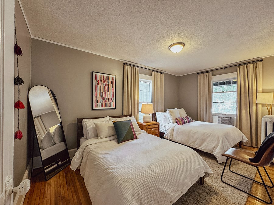 The fourth bedroom includes two full beds with organic linens, blackout window coverings, a dresser, bedside lighting, bathrobes, and phone chargersideal for children, coworkers, or family members sharing the home.