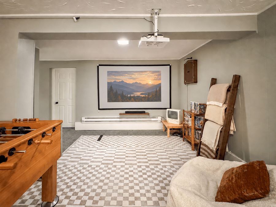 Enjoy movie night in the basement theater with a large projector screen, comfortable seating, streaming capability, and an air-pop popcorn maker for the full at-home theater experience.