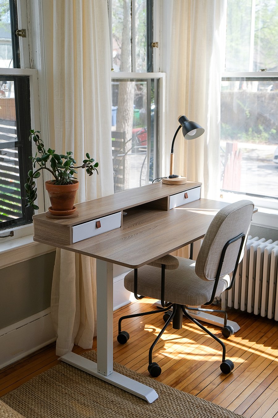 The dedicated sunroom workspace offers abundant natural light, a spacious adjustable standing desk, comfortable seating, and fast fiber WiFi for remote work, studying, or managing life between homes.