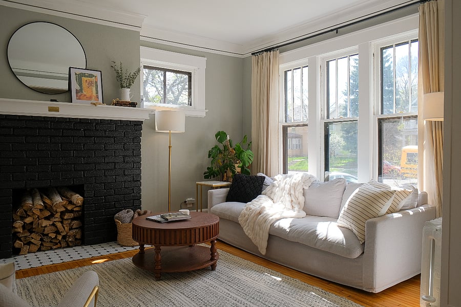 Thoughtfully furnished for time together, the main living space includes comfortable seating, a piano, guitar, record player, Smart TV, original 1915 details, and warm natural light.
